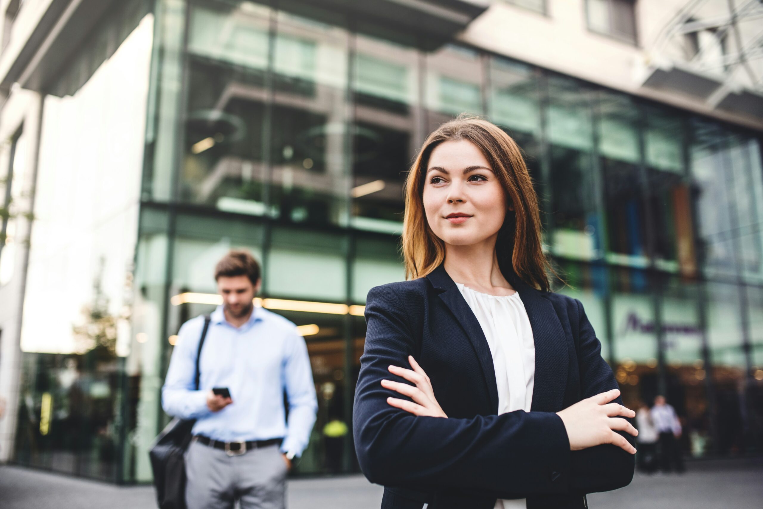 A woman in her 30s standing in front of an office block