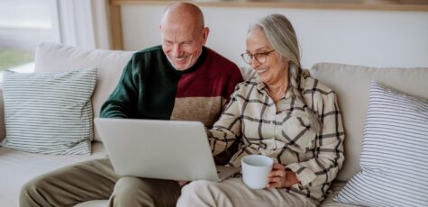 A couple sat on a beige couch reviewing their options for delayed retirement